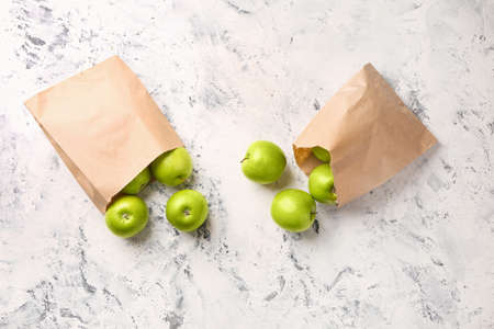 Paper bags with fresh ripe apples on light backgroundの写真素材