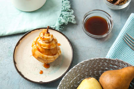 Plate with tasty cooked pear on tableの写真素材