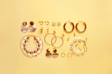 Stylish female jewelry on color background