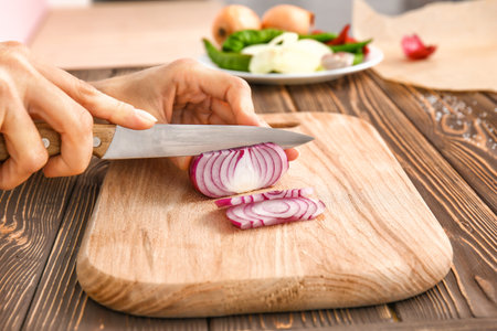 Woman cutting onion in kitchen, closeupの写真素材
