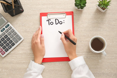 Woman making to-do list at table, top viewの写真素材