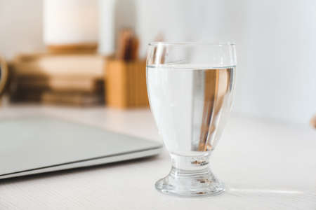 Glass of fresh water on table in roomの写真素材