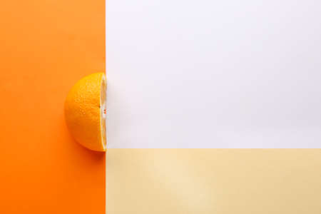 Half of fresh orange fruit on color background