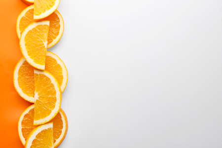 Slices of fresh orange fruit on color backgroundの写真素材