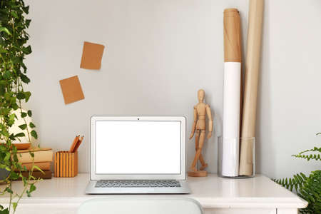 Modern stylish workplace with laptop near white wallの写真素材
