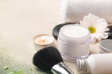 Cosmetic cream with brush on light background