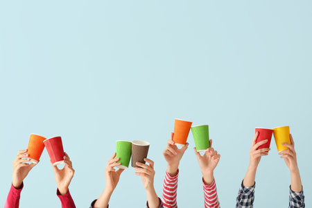 Many hands with cups for coffee on color background