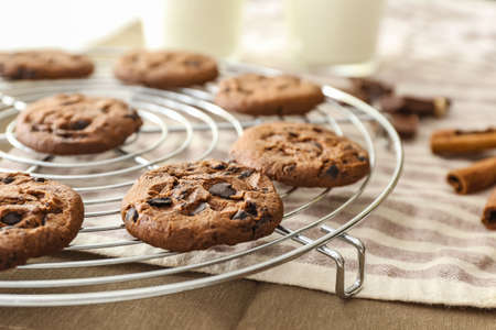 Tasty chocolate cookies on cooling rack, closeup
