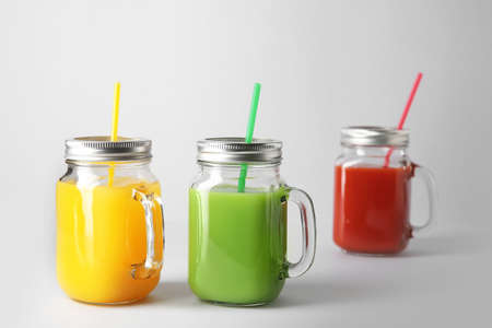 Mason jars of fresh juice on gray backgroundの写真素材