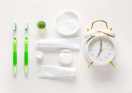 Set for dental hygiene and clock on light backgroundの写真素材