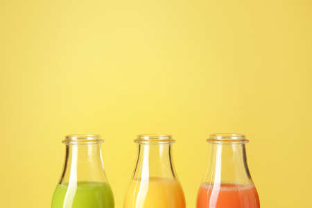 Bottles of fresh juice on color backgroundの写真素材