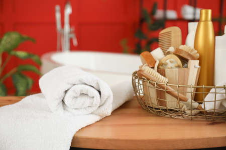 Clean towels with cosmetics and supplies on table in bathroomの写真素材