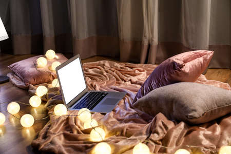 Cozy place with laptop and glowing garland at home