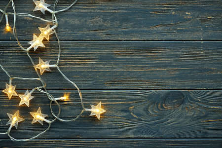 Beautiful glowing garland on dark wooden background