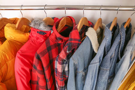 Stylish clothes on hangers in show room, closeup
