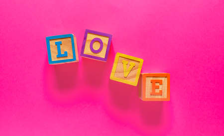 Word LOVE composed from cubes on color background