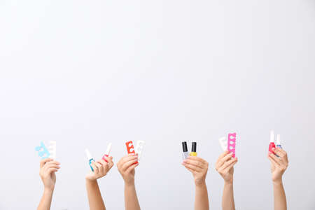 Many hands with supplies for pedicure on white background