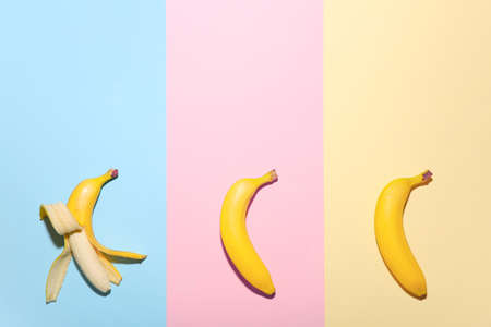 Peeled banana among unpeeled ones on color background. Concept of uniquenessの写真素材