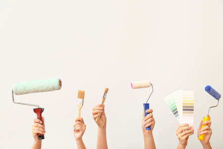 Female hands with painter's tools on white backgroundの写真素材
