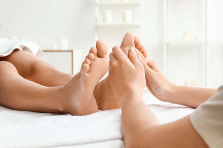 Young woman having feet massage in spa salonの写真素材