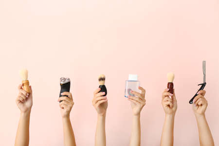 Hands with different tools for shaving on color backgroundの写真素材