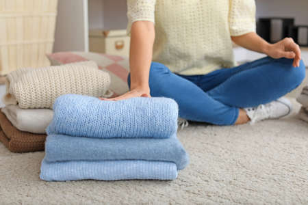 Woman with stacks of clean clothes at homeの写真素材