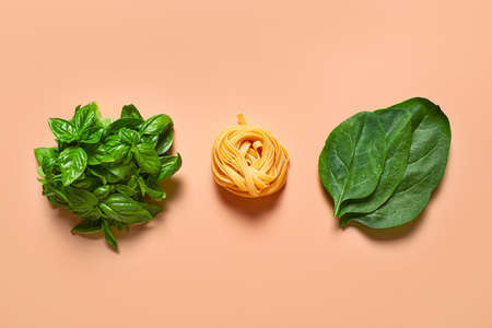 Dry pasta with fresh herbs on color backgroundの写真素材