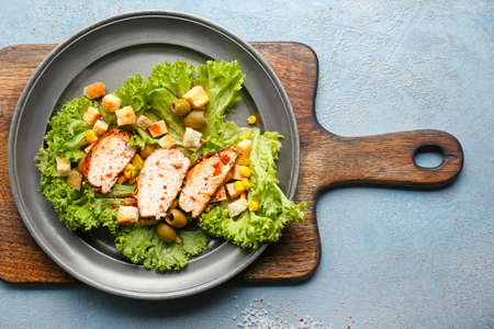 Plate with tasty chicken salad on color backgroundの写真素材