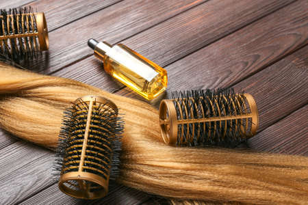 Hair strand, curlers and oil on wooden backgroundの写真素材