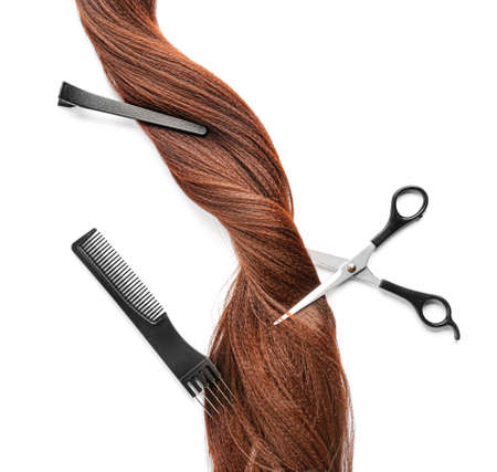 Hair strand and hairdresser's tools on white background
