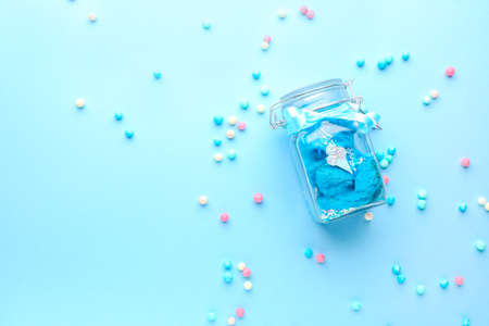 Jar with tasty cotton candy and sprinkles on color backgroundの写真素材