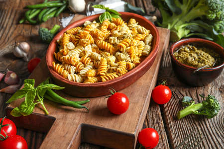 Plate with tasty pasta and pesto sauce on wooden tableの写真素材