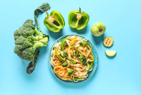 Plate with tasty pasta and vegetables on color backgroundの写真素材