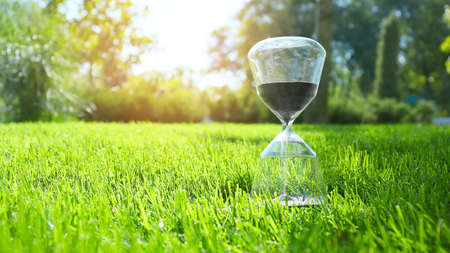 Hourglass on green grass outdoors
