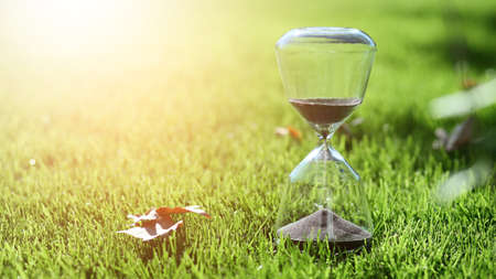 Hourglass on green grass outdoors