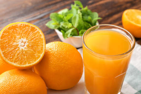 Glass of fresh orange juice with mint on tableの写真素材