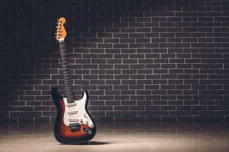 Modern bass guitar against brick wallの写真素材