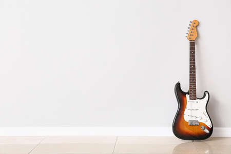 Modern bass guitar near white wallの写真素材