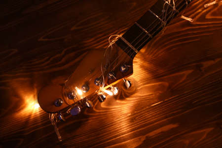 Acoustic guitar with Christmas lights on wooden backgroundの写真素材