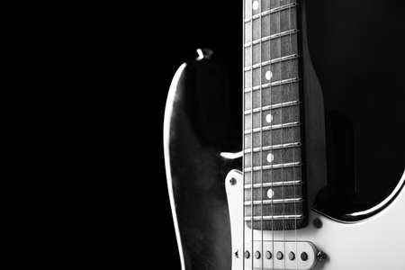 Black and white photo of modern bass guitar against dark background, closeupの写真素材