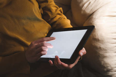 Young woman with tablet computer at home late in eveningの写真素材