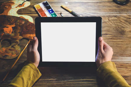Female artist with tablet computer at home late in eveningの写真素材