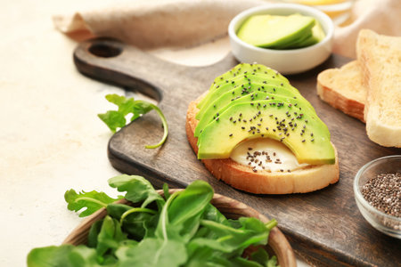 Board with tasty sandwich on table