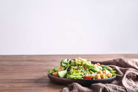 Plate with tasty salad on tableの写真素材