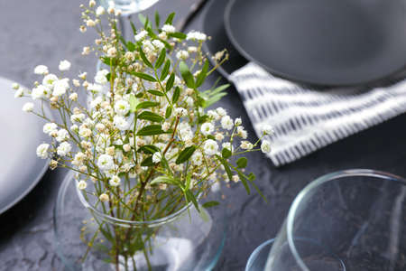 Vase with flowers on served table, closeup