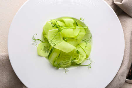 Plate with tasty cucumber salad on table, closeup