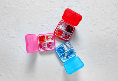 Containers with different pills on white background