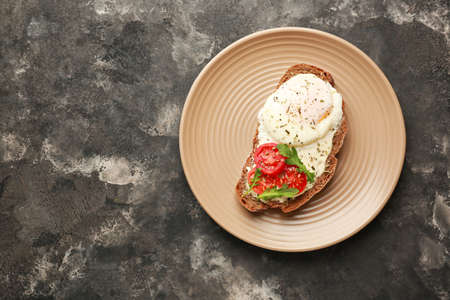 Plate with tasty sandwich on dark background