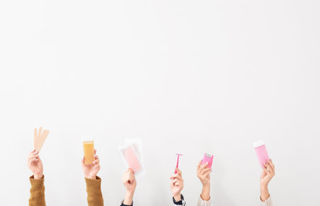 Female hands with supplies for hair removing on white backgroundの写真素材
