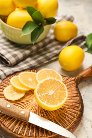 Cutting board with ripe lemon and knife on light backgroundの写真素材